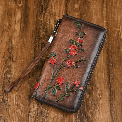 Dark brown wallet with red embossed flower branches and wrist strap
