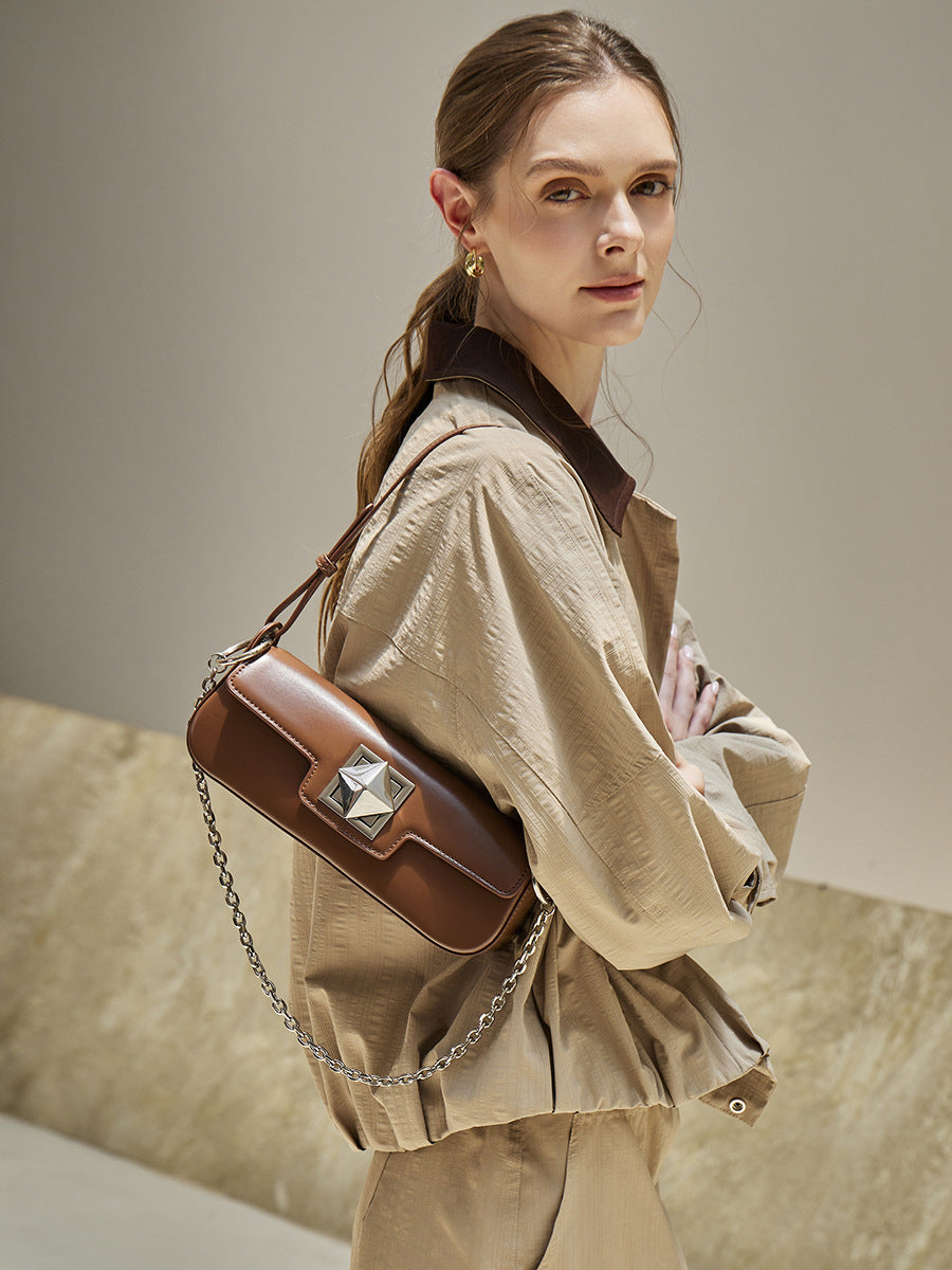 Model wearing caramel leather baguette shoulder bag with a beige outfit