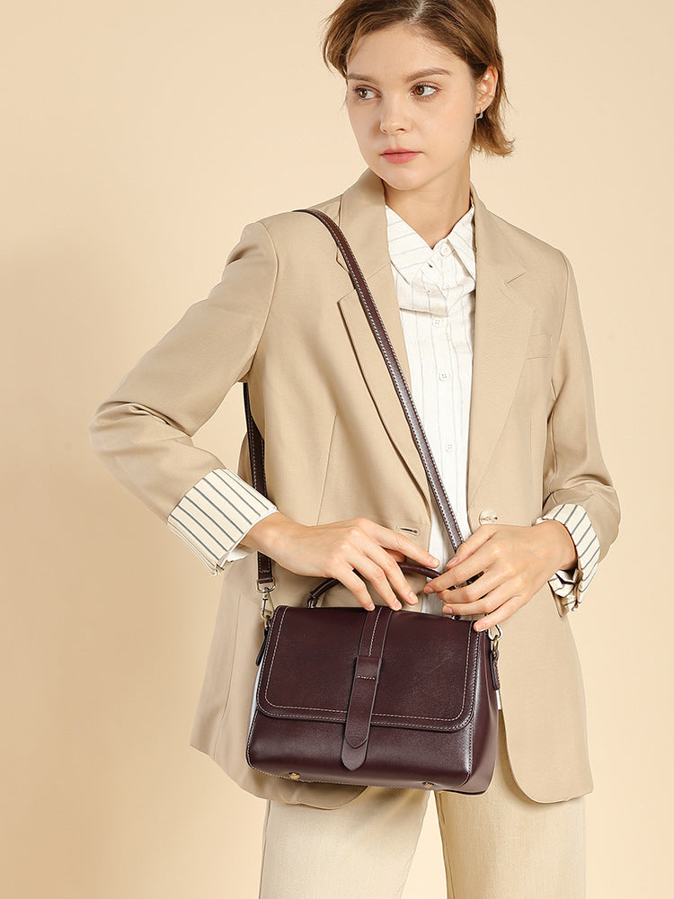 Model wearing the wine brown leather Boston bag over the shoulder with strap