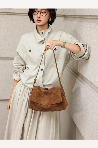 Dark brown suede bag shown full length with a shoulder strap