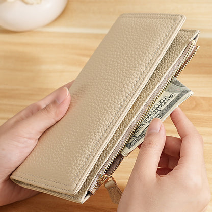 Beige pebbled cowhide wallet holding paper cash beside its zip pocket