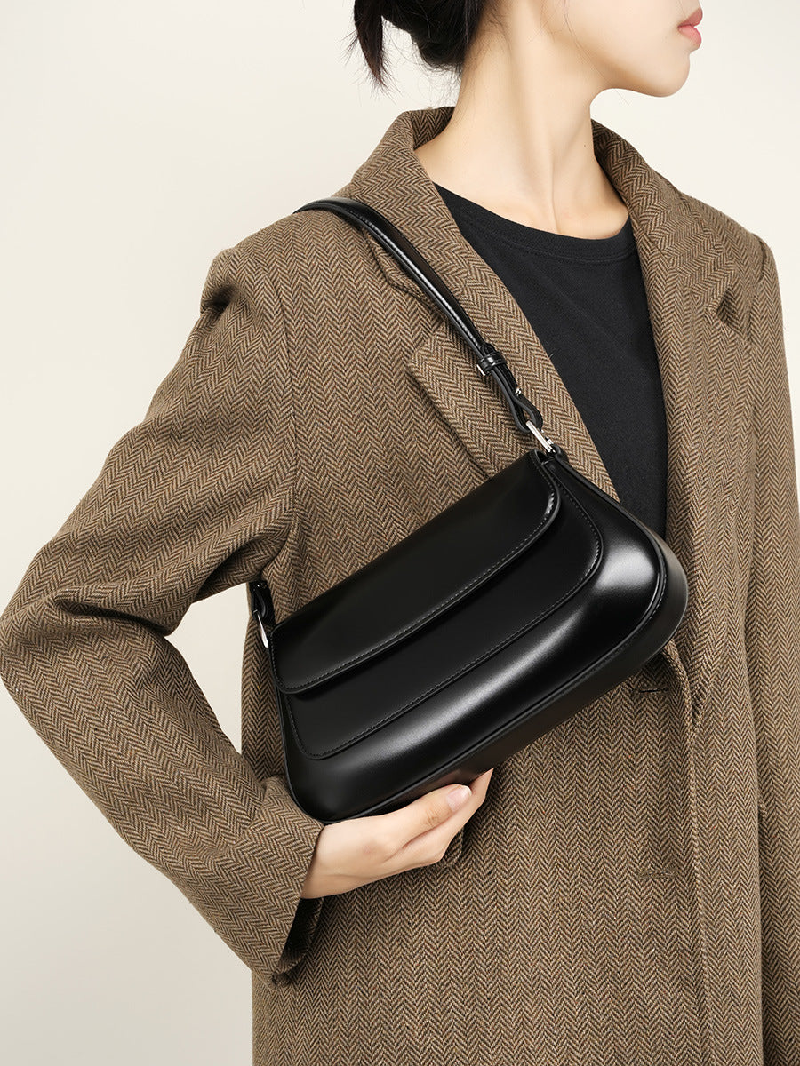 Close-up of the black leather baguette bag's front flap and stitching