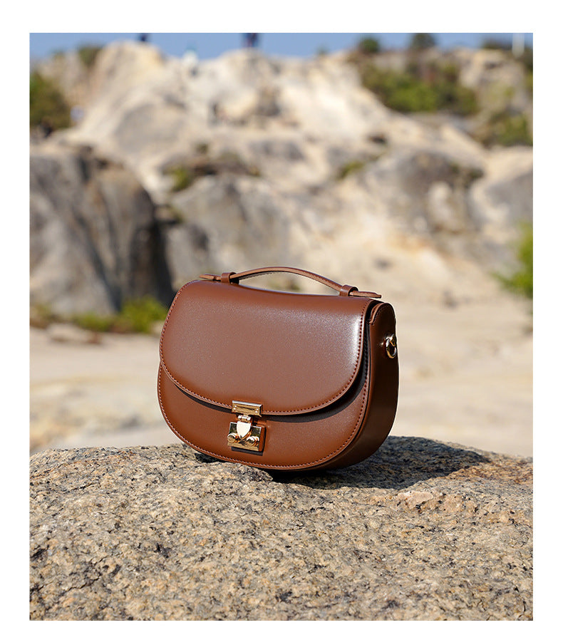 Brown saddle bag placed on a rocky surface outdoors