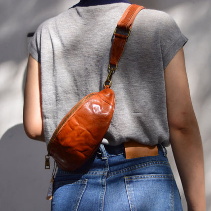Close rear view of the brown leather sling bag and strap