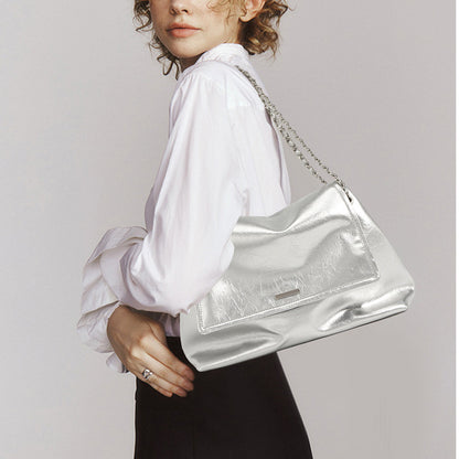 Silver leather chain shoulder bag styled over the shoulder with a white blouse
