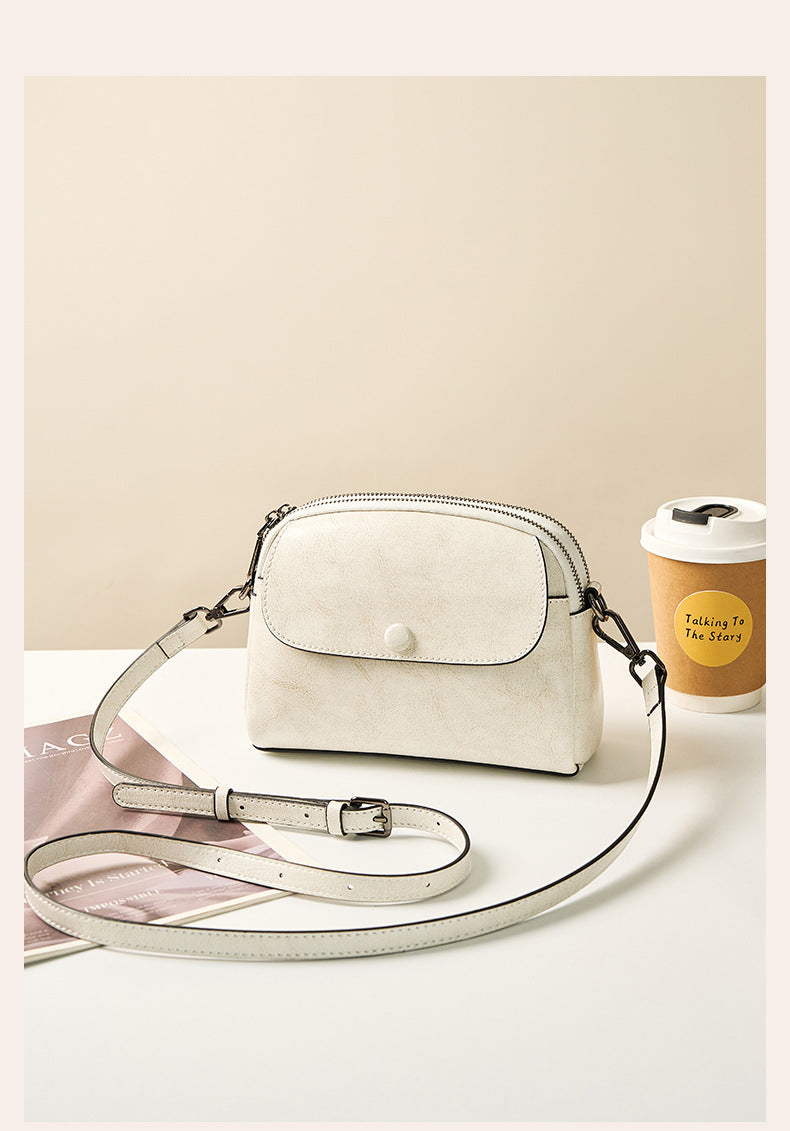 Pearl white crossbody bag styled with magazine and coffee cup