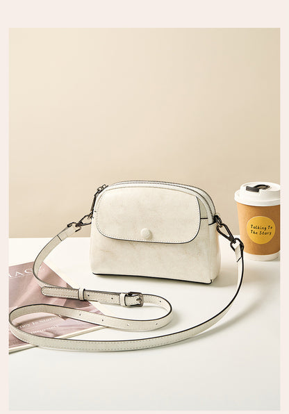 Pearl white crossbody bag styled with magazine and coffee cup