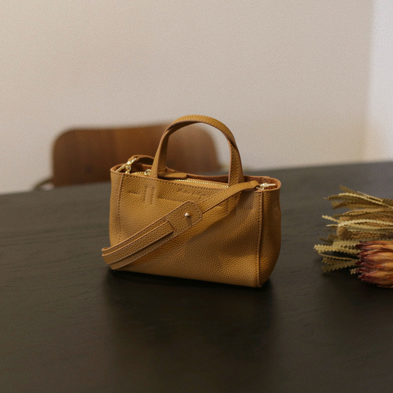 Sesame pebbled cowhide mini tote with top handles and shoulder strap