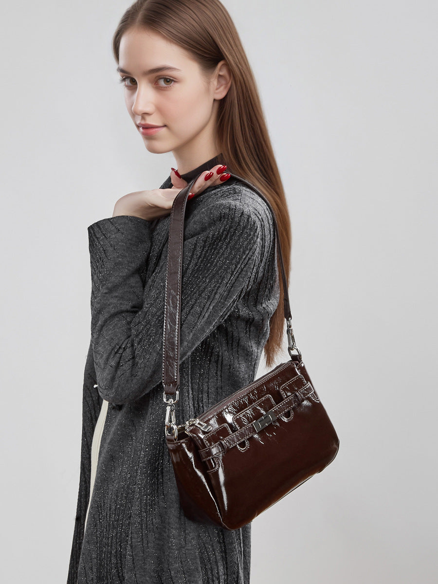 Wine red bag worn on shoulder by model in grey dress