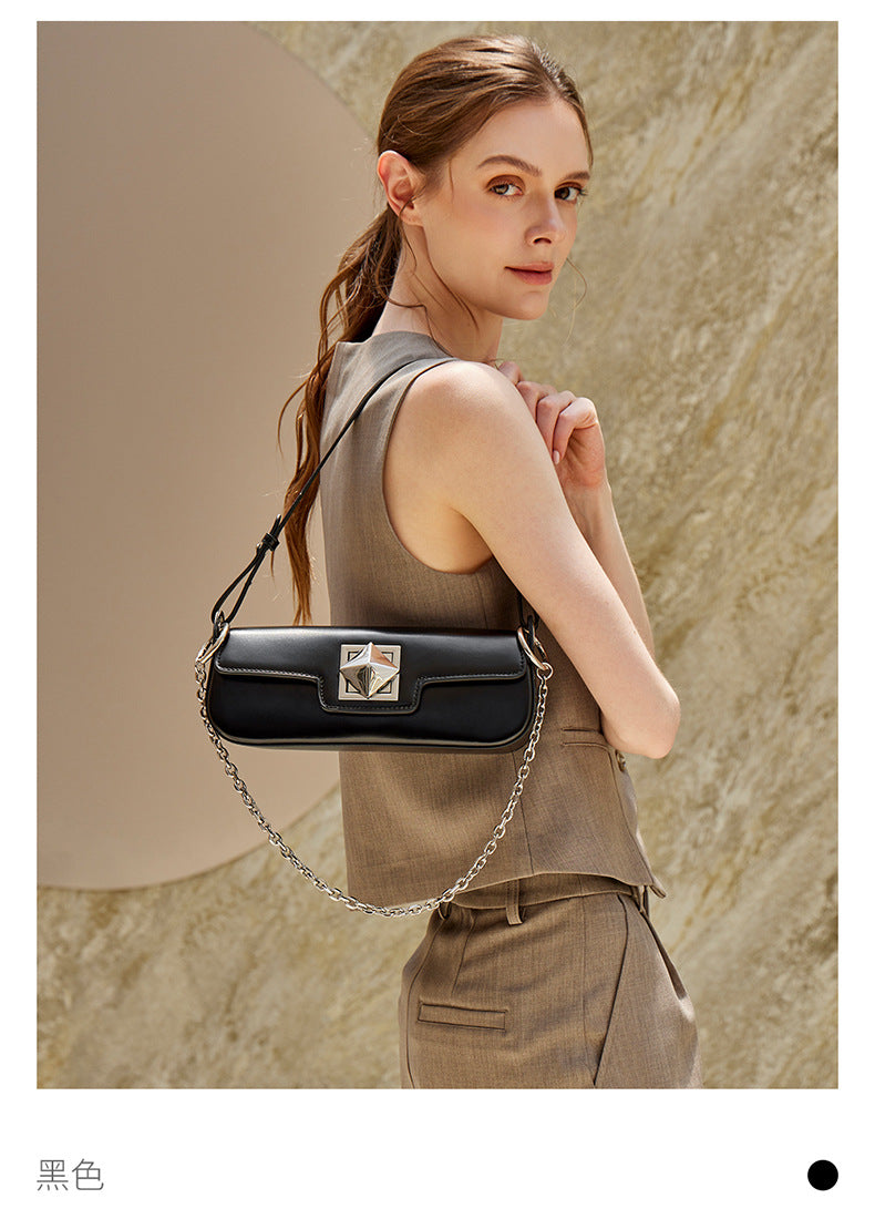 Model holding off-white leather baguette shoulder bag with chain strap