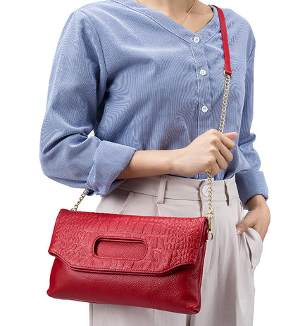 Red envelope clutch worn over the shoulder with chain strap