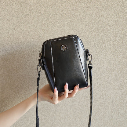 Black cowhide leather mini crossbody phone bag held in hand