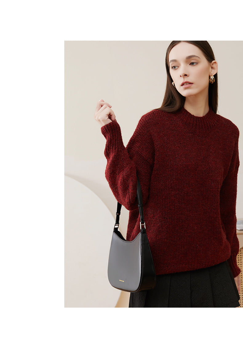Model wearing black cowhide leather underarm shoulder bag with burgundy knit sweater