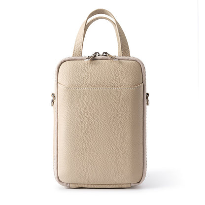 Off-white top-grain cowhide vertical phone crossbody bag with twin top handles and front slip pocket on white background