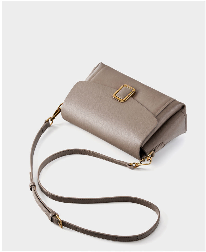 Gray cowhide leather crossbody bag laid flat showing adjustable strap detail