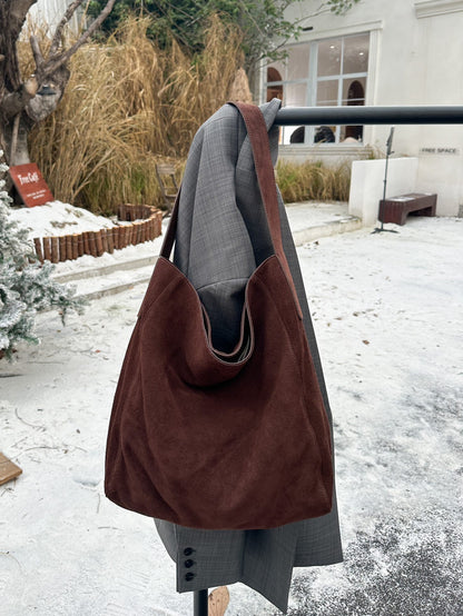 Burgundy suede cowhide tote in a hanging view