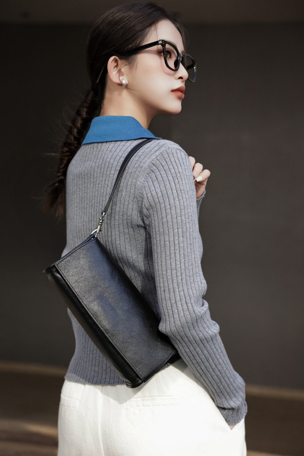 Coffee flap bag worn with a dark tailored outfit