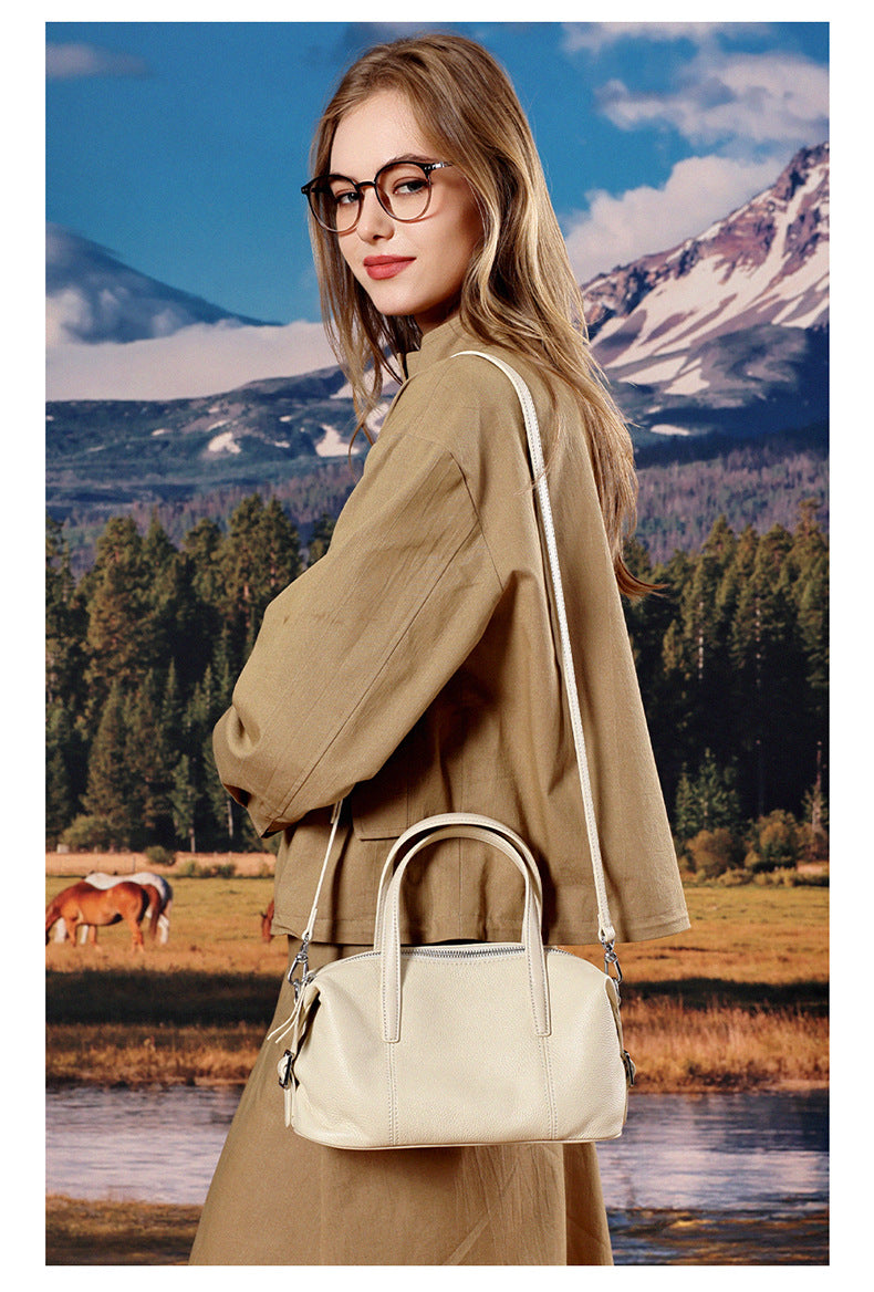 Model carrying off-white bag crossbody near lake