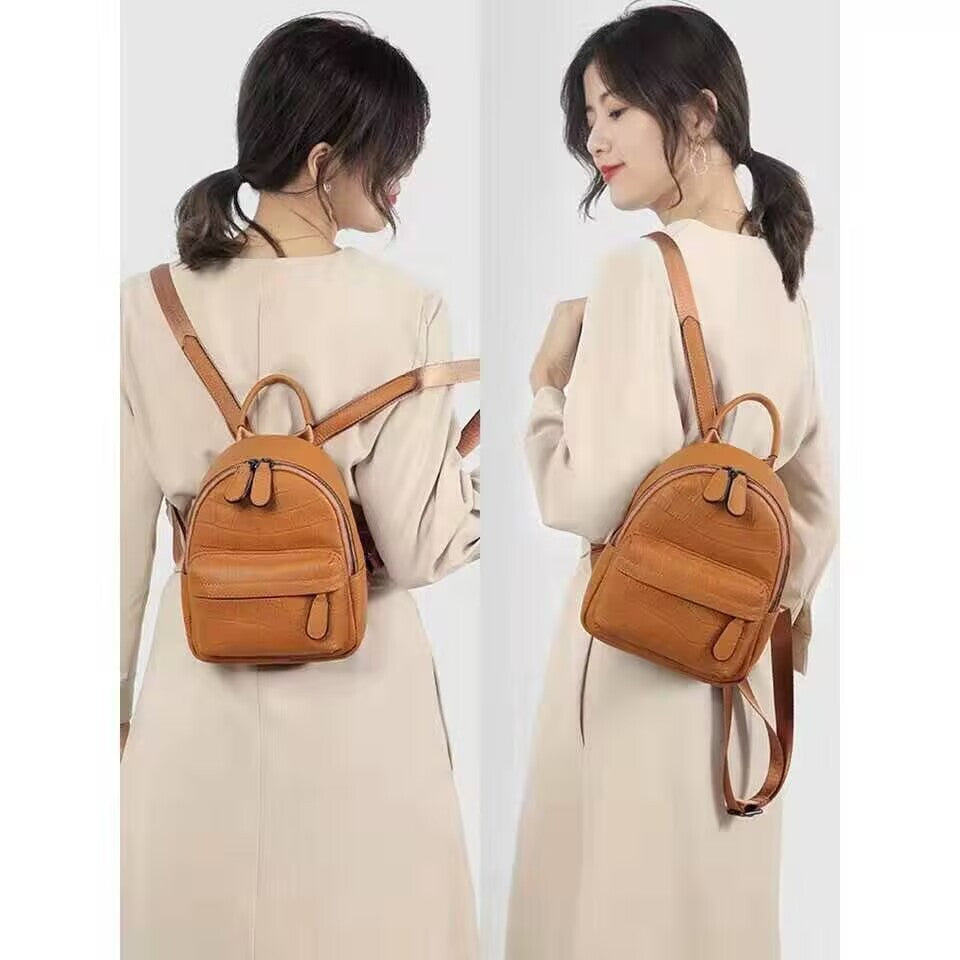 Back view and angled view of a tan mini backpack worn on the shoulders