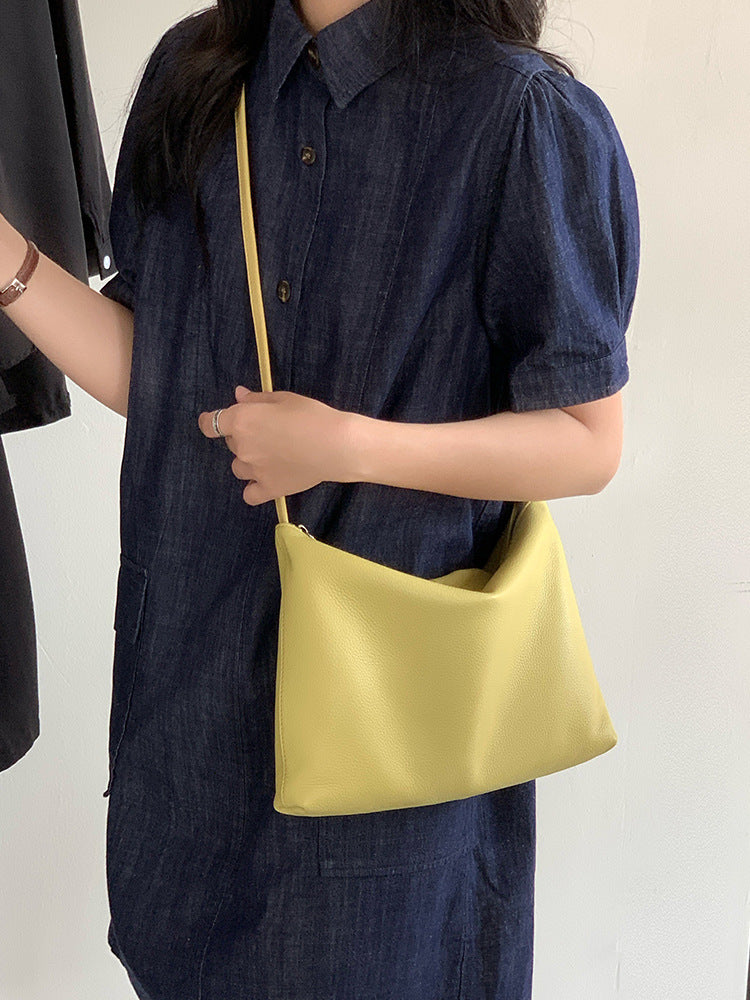 Yellow hobo shoulder bag carried with a dark outfit