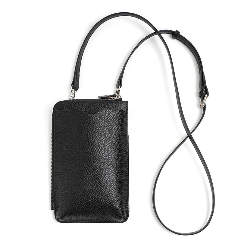 Black leather phone bag laid flat with long adjustable strap fully extended