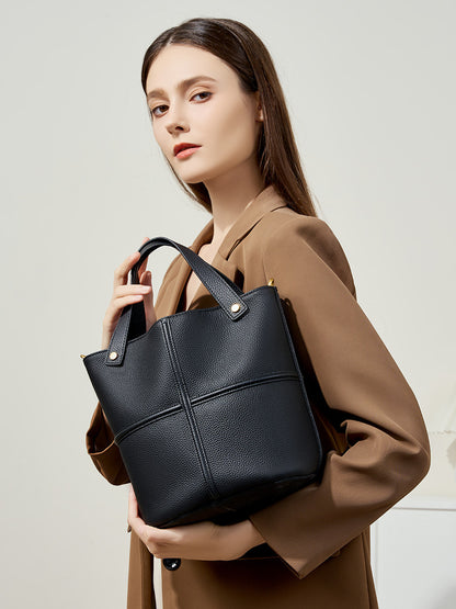 Model wearing black bucket bag as a shoulder bag