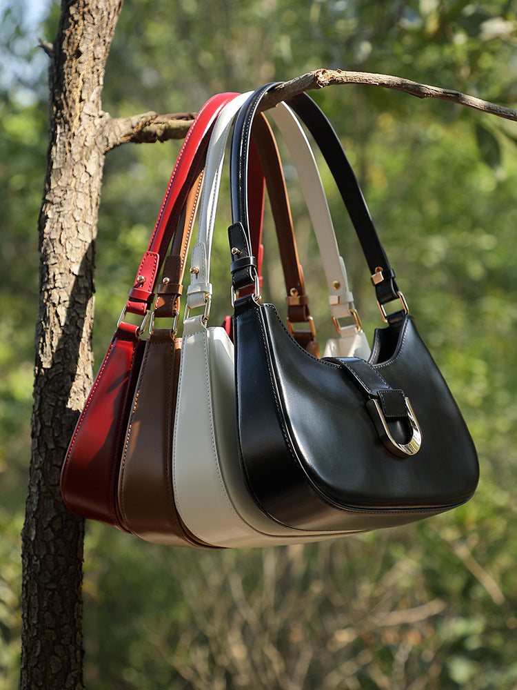 Four colorways of shoulder bag hanging on tree branch