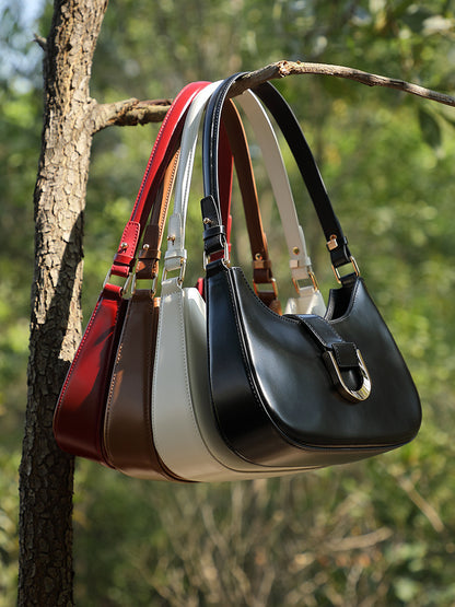 Four colorways of shoulder bag hanging on tree branch