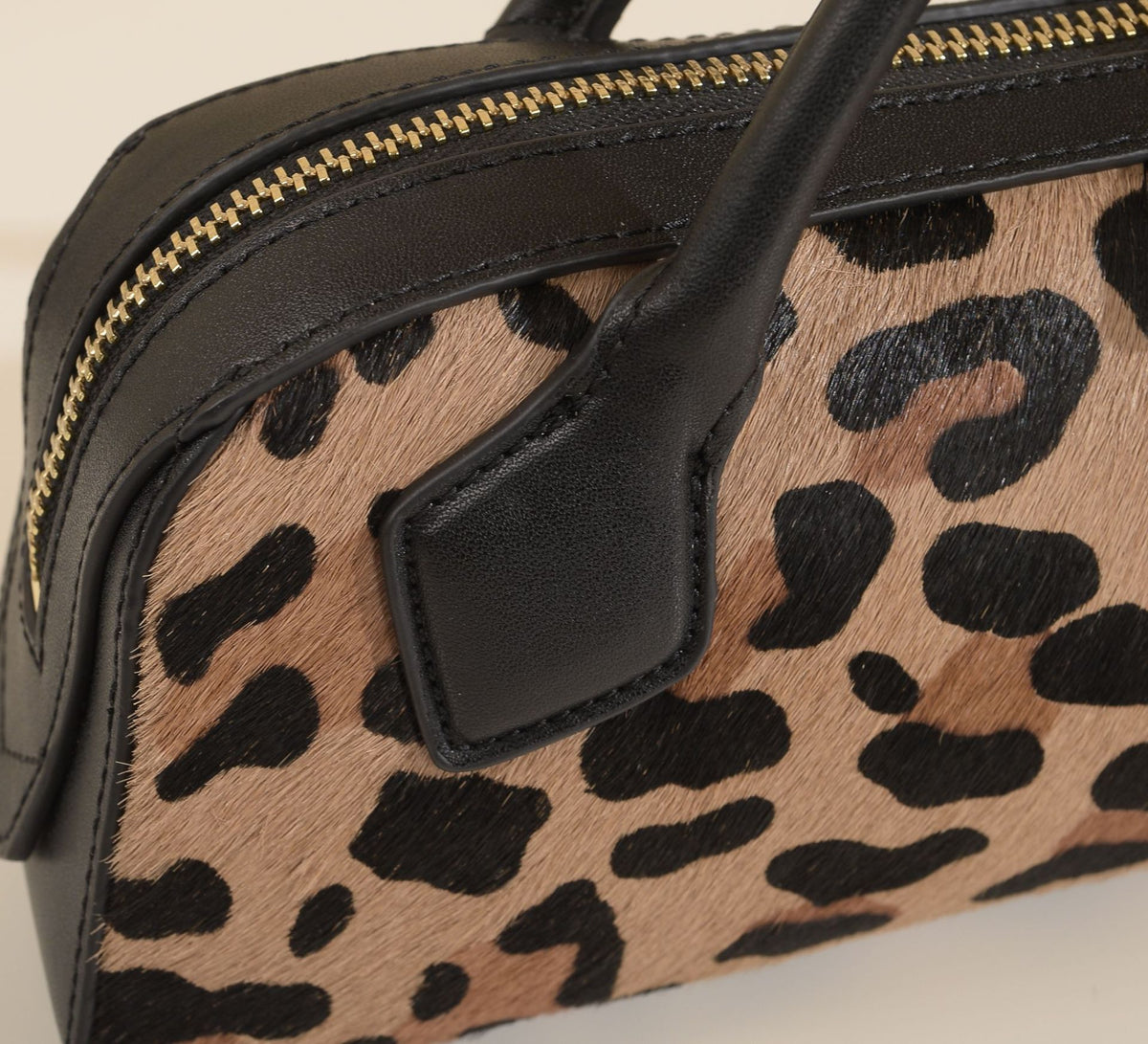 Leopard-print exterior detail with black leather handle attachment