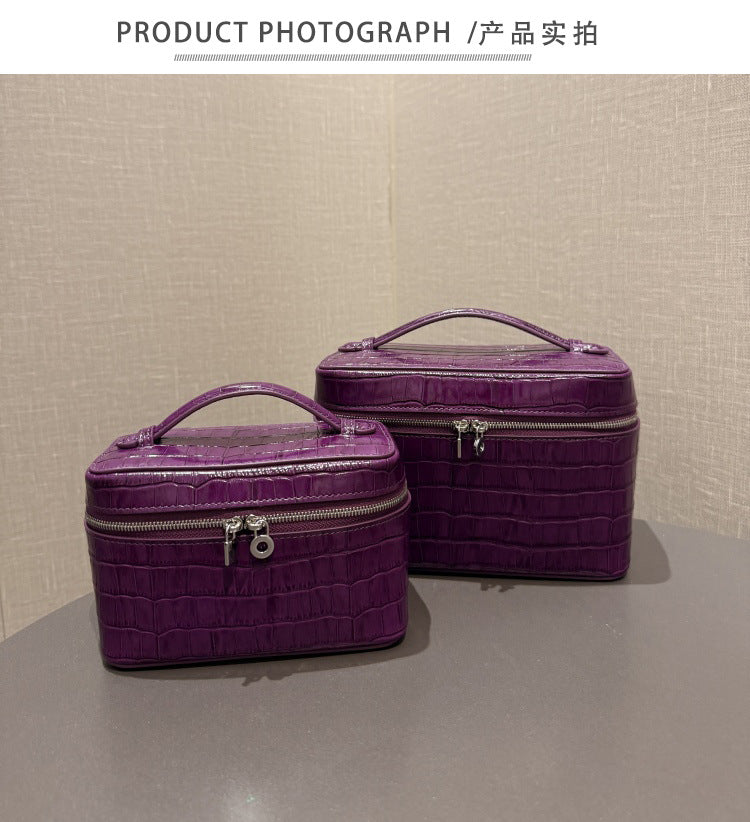 Front view of a purple crocodile-embossed cosmetic pouch