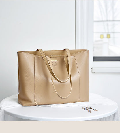 Apricot leather tote bag styled on a round white table near a window