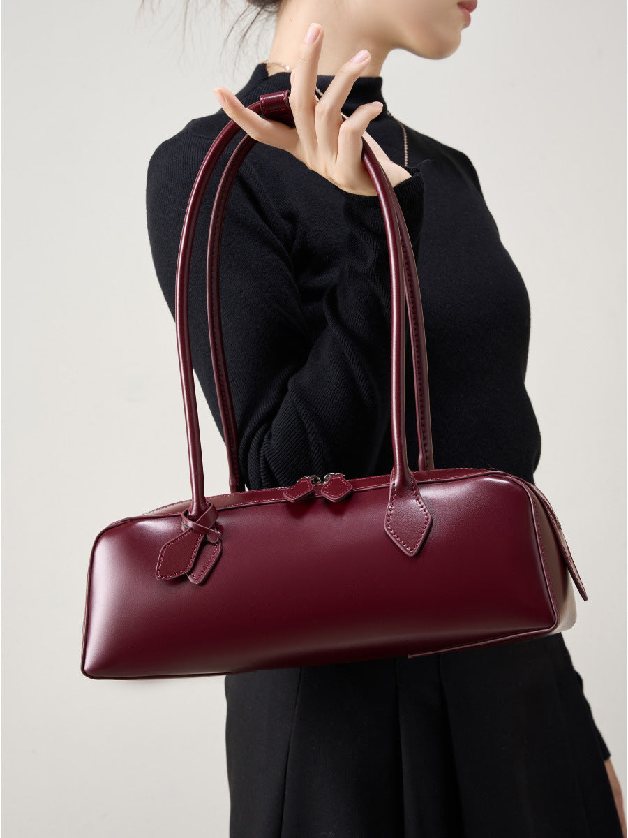 Wine red leather baguette bag on model in black top