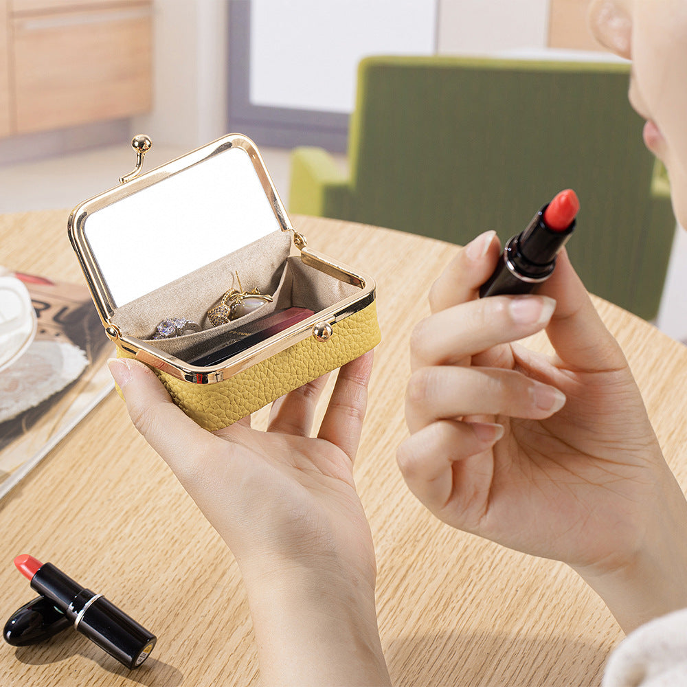 Yellow pouch open for a lipstick touch-up with built-in mirror