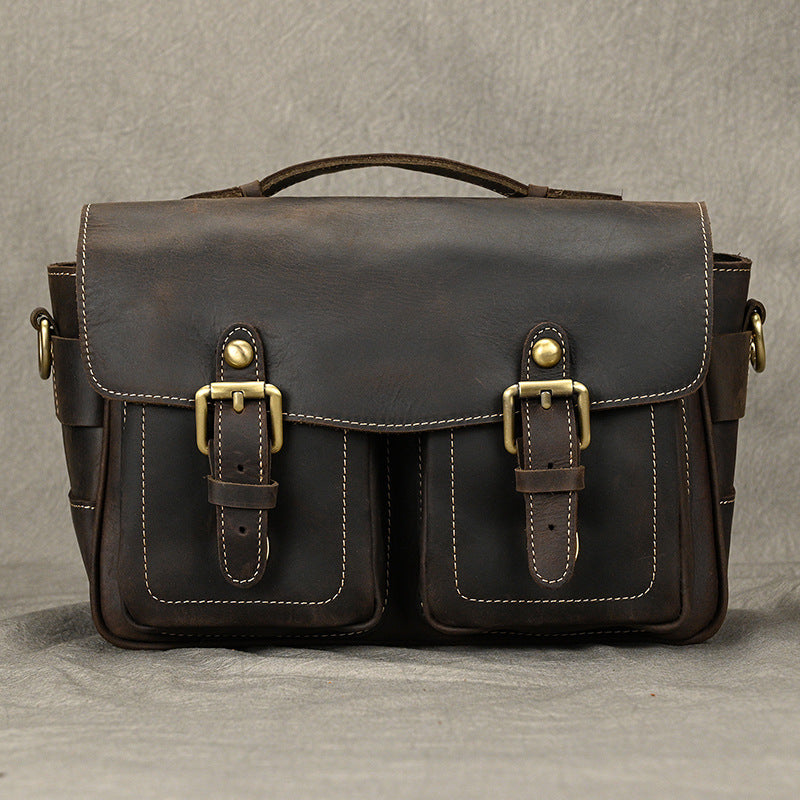 Front view of dark brown leather camera crossbody bag with two buckle pockets