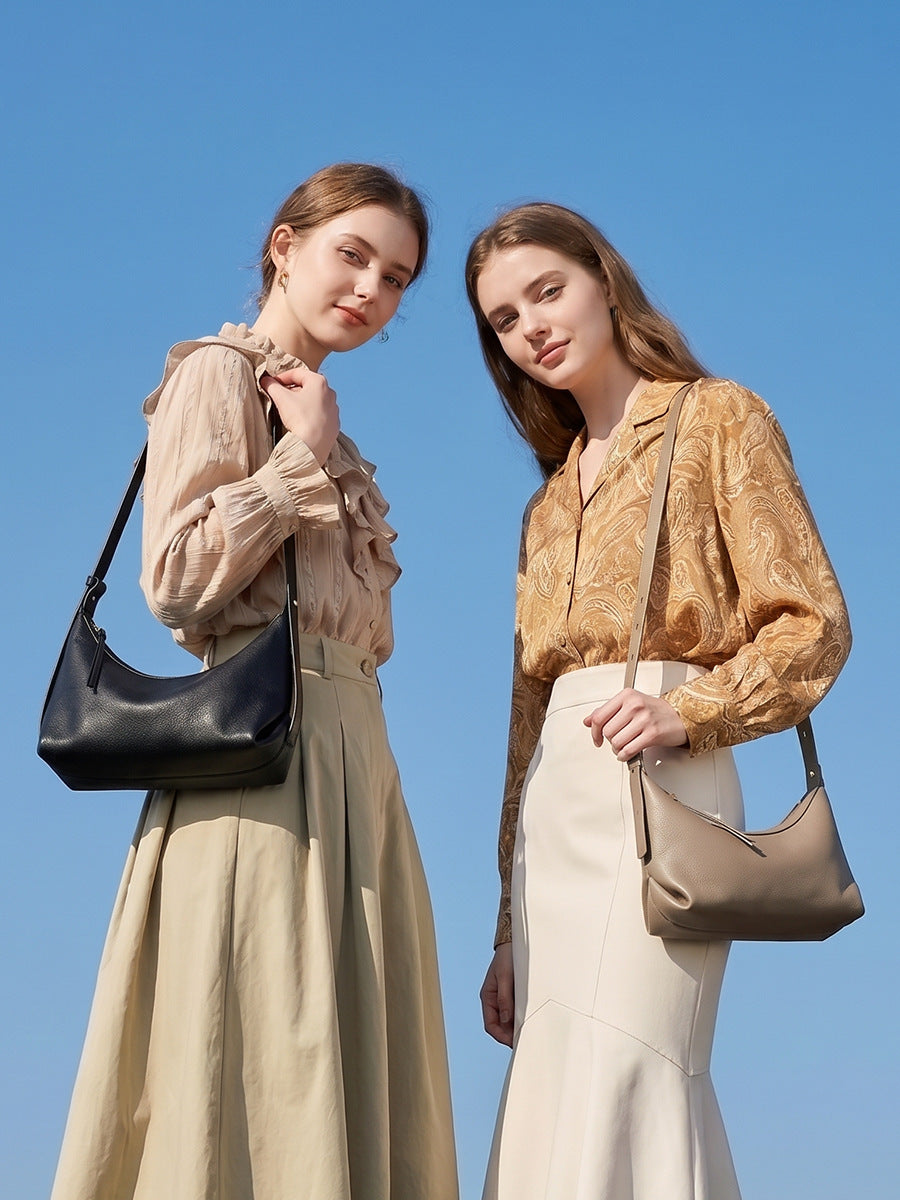 Two models wearing leather hobo bags outdoors