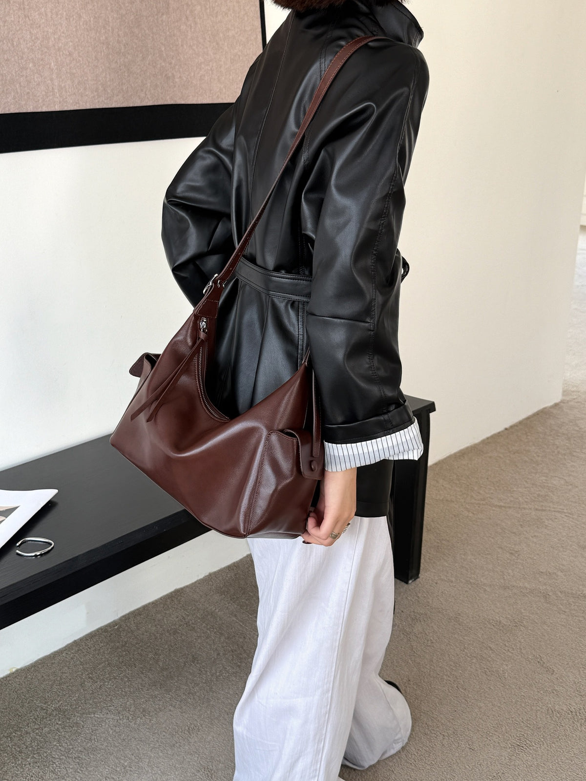 Model carrying the brown leather bag at her side