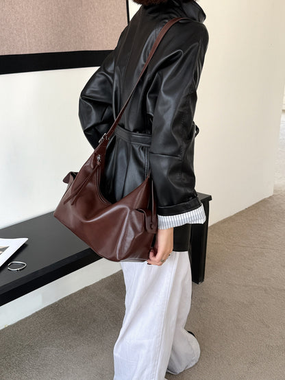 Model carrying the brown leather bag at her side
