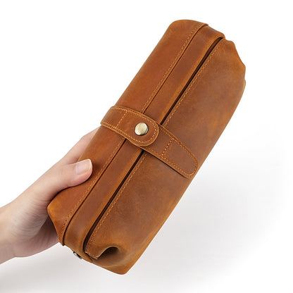 Brown leather pouch shown from the side in hand