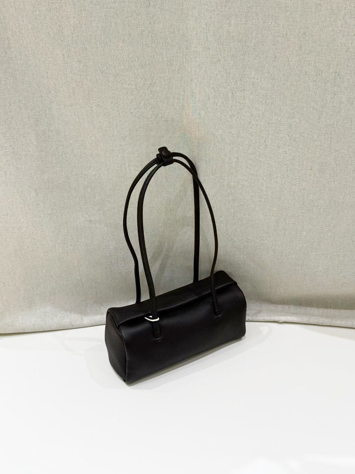 Black leather shoulder bag showing its soft pillow shape