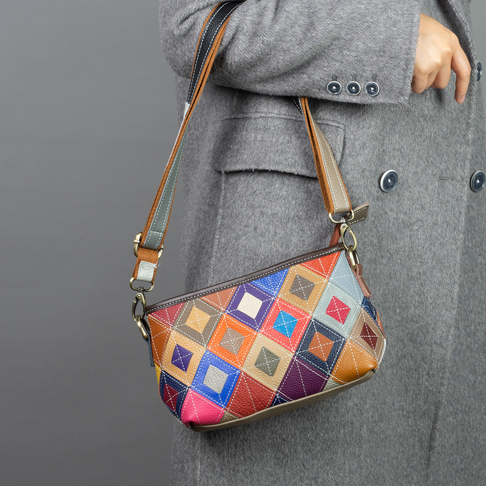 Multicolor geometric patchwork cowhide crossbody bag worn over a coat