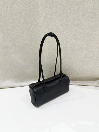 Black cowhide pillow shoulder bag shown at an angle