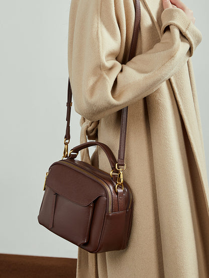 Chocolate brown Boston crossbody bag worn over the shoulder with gold-tone hardware