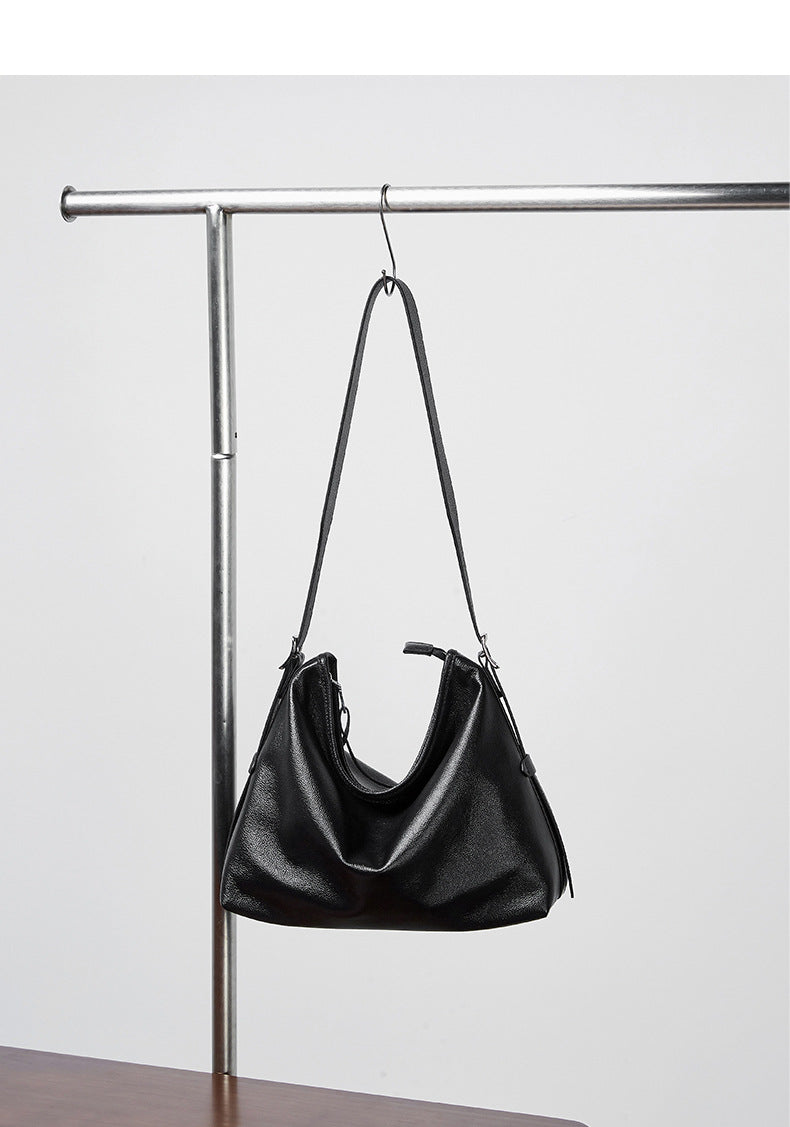 Black leather bag hanging from a metal rack