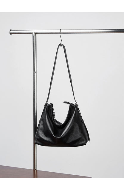Black leather bag hanging from a metal rack