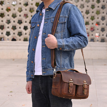 Brown camera bag worn crossbody with denim jacket