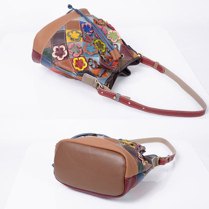 Angled view of floral patchwork bucket bag and shoulder strap
