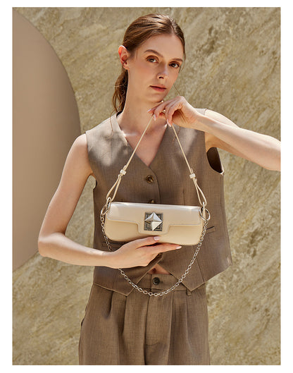 Model wearing off-white leather baguette shoulder bag, side view