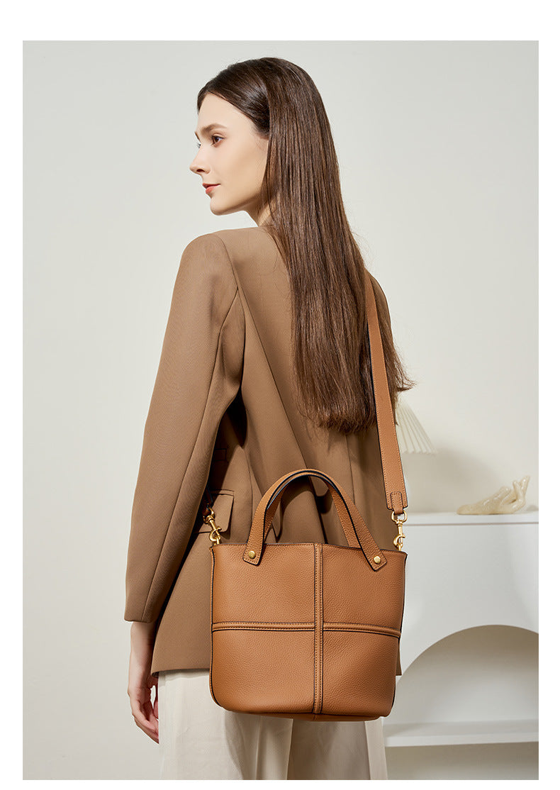 Model carrying the brown bucket bag over her shoulder