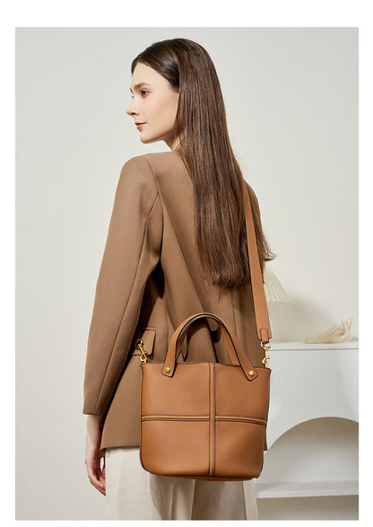 Model carrying the brown bucket bag over her shoulder