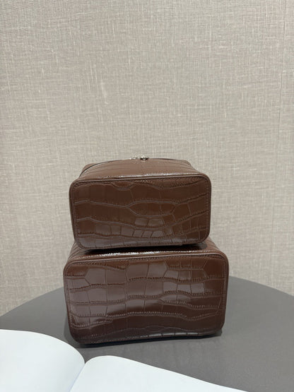 Rear view of two crocodile-embossed chocolate cosmetic pouches